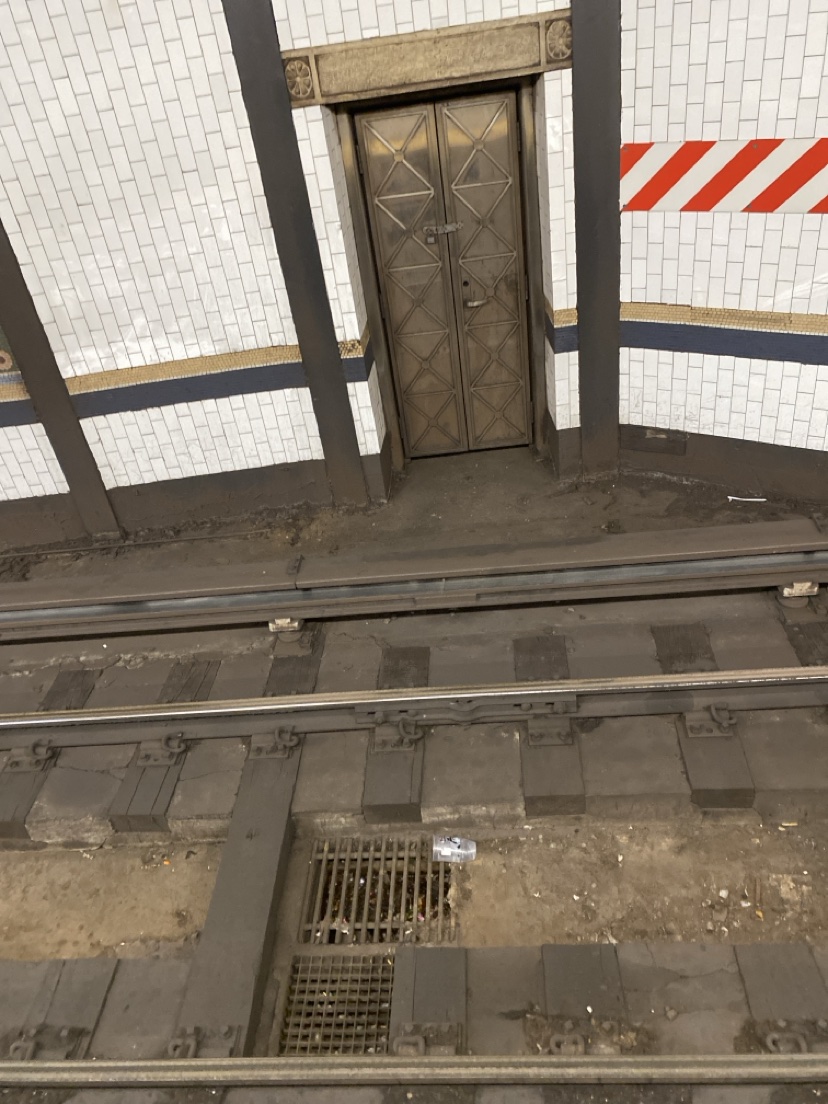 Ancient riveted metal service door across the tracks